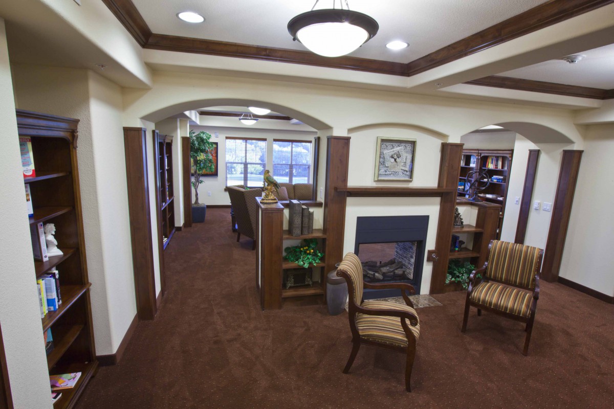 A cozy lobby interior with a fireplace, comfortable seating, and elegant lighting.