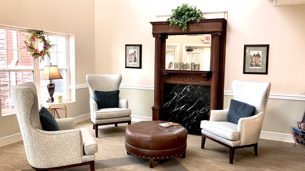 A cozy living room featuring a fireplace, comfortable chairs, and a central coffee table.