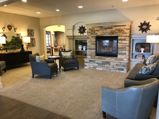 A cozy living room with comfortable seating and a stone fireplace.