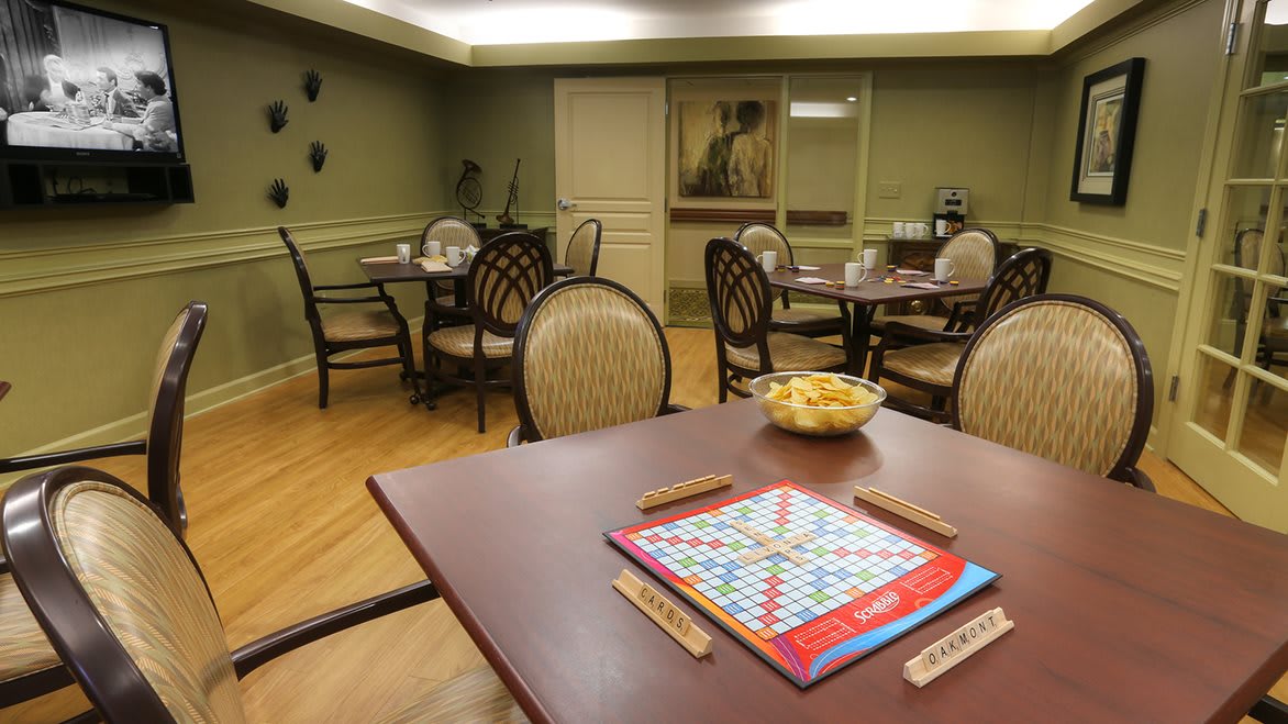 A cozy room with tables and chairs set up for playing a game of Scrabble.