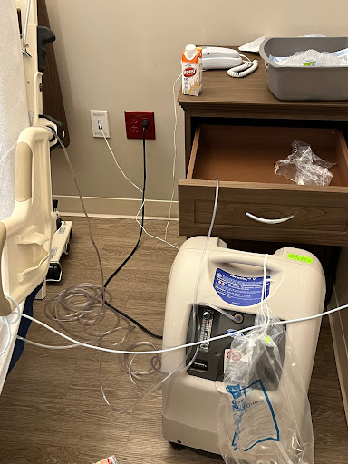 A hospital room equipped with an oxygen machine and various connected wires.