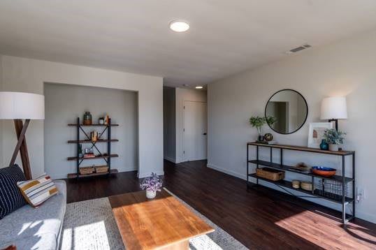 A modern, minimalist living room with hardwood floors and stylish decor.