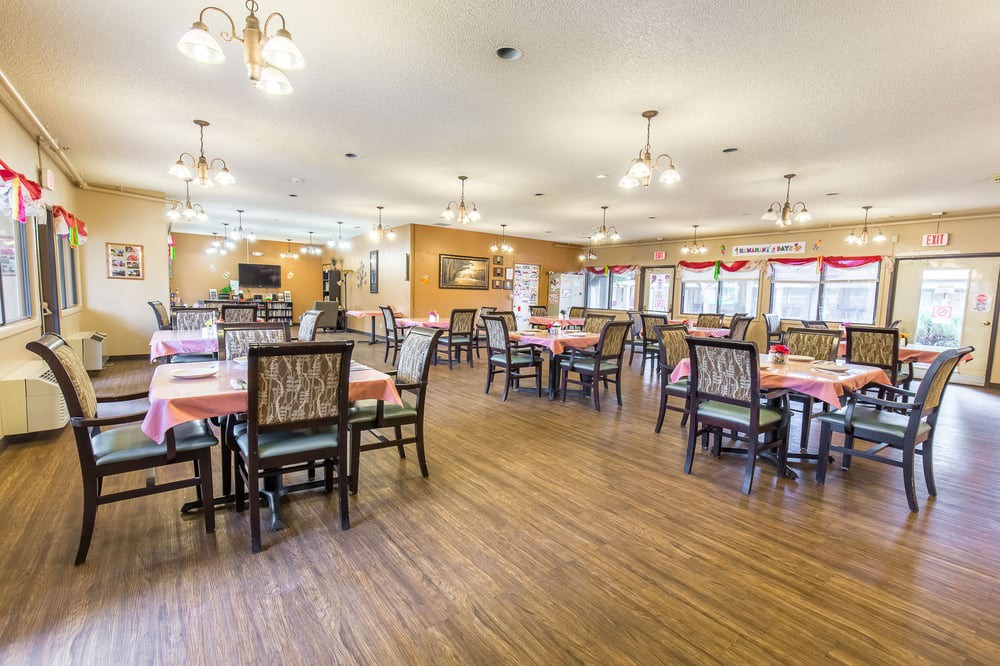 A spacious dining area with neatly arranged tables and chairs, well-lit by overhead lights.