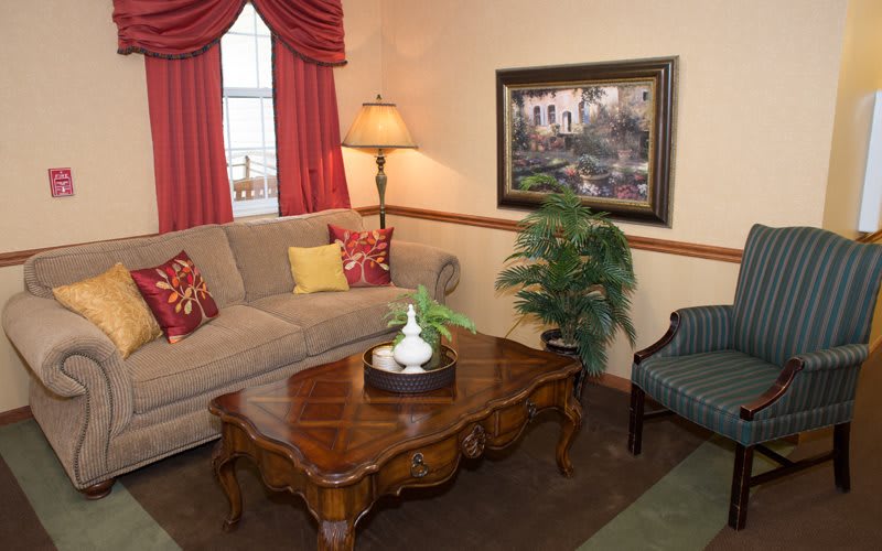 A cozy living room with a comfortable sofa, wooden coffee table, and warm lighting.