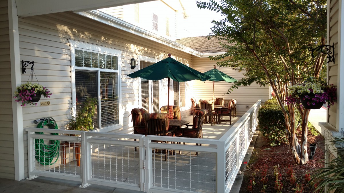 A cozy patio with outdoor furniture and umbrellas on a sunny day.