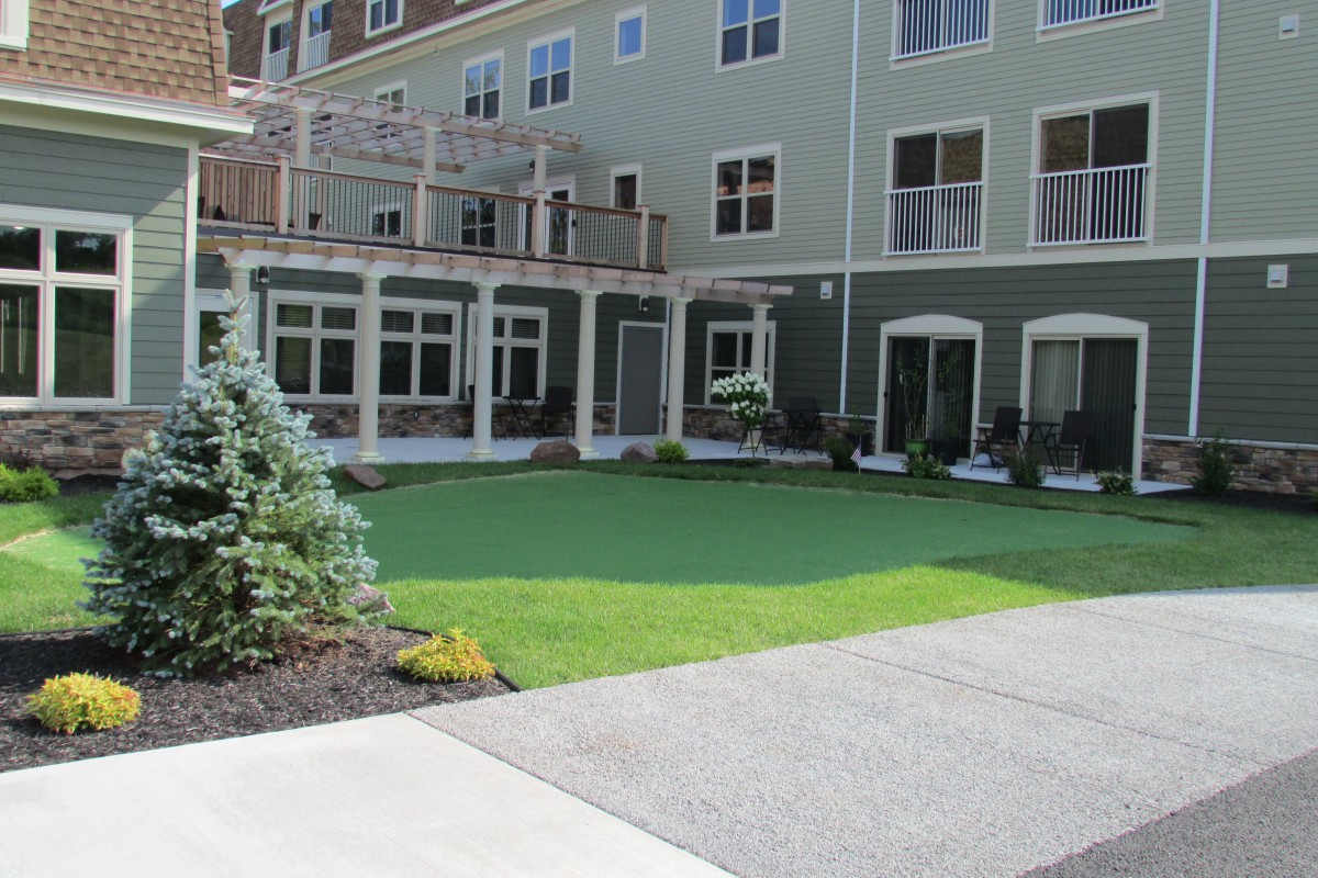 A well-maintained lawn area in front of a modern multi-story building.