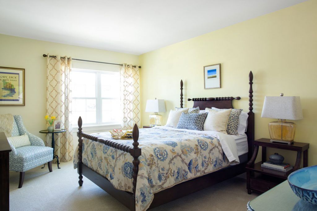 A cozy bedroom with a large bed, decorated with floral bedding and soft lighting.