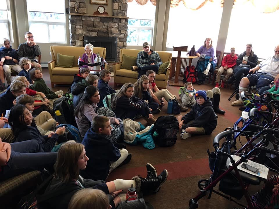 A group of children and an elderly person gathered indoors for a social event.