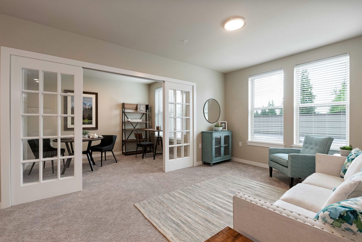 A modern living room with natural light, featuring French doors and stylish decor.
