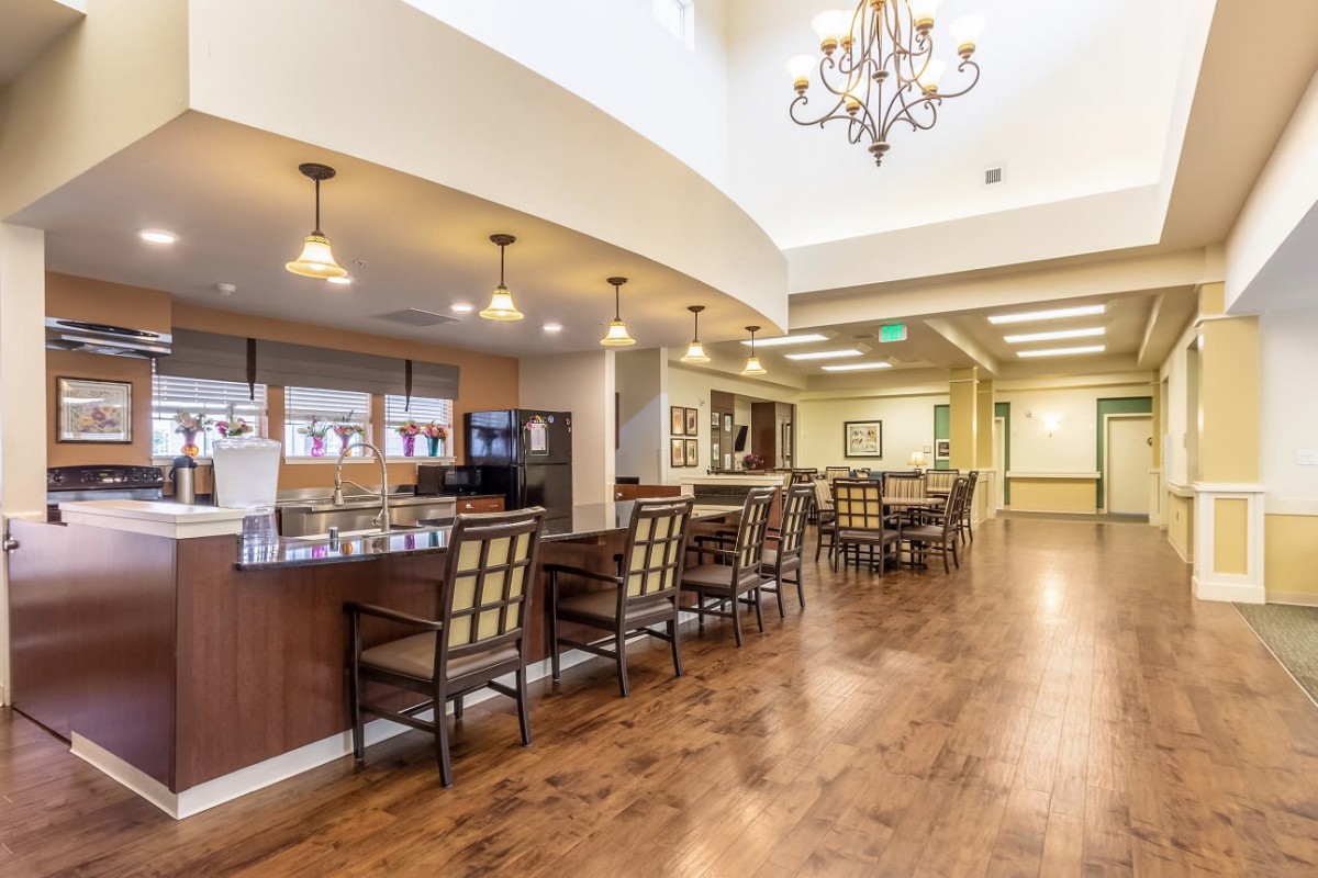 A modern dining area featuring a chandelier and wooden flooring.