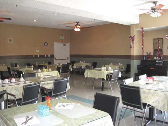 An empty dining room with neatly arranged tables and chairs, ready for service.