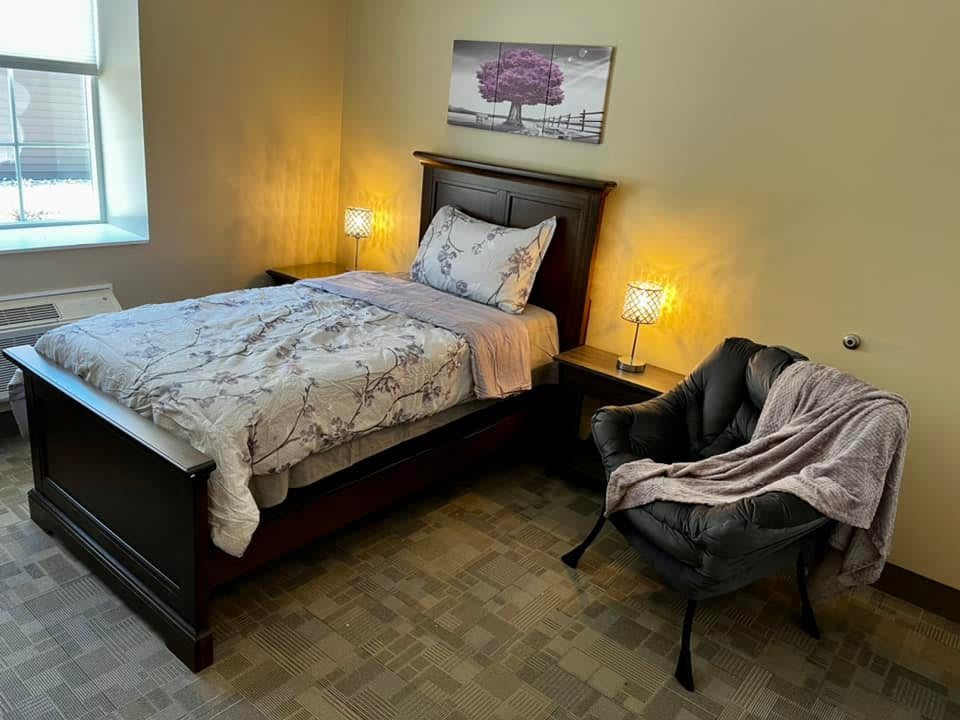 A cozy bedroom with a neatly made bed and stylish decor.