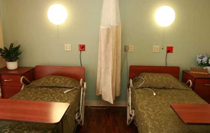 A hospital room with two beds separated by a curtain.