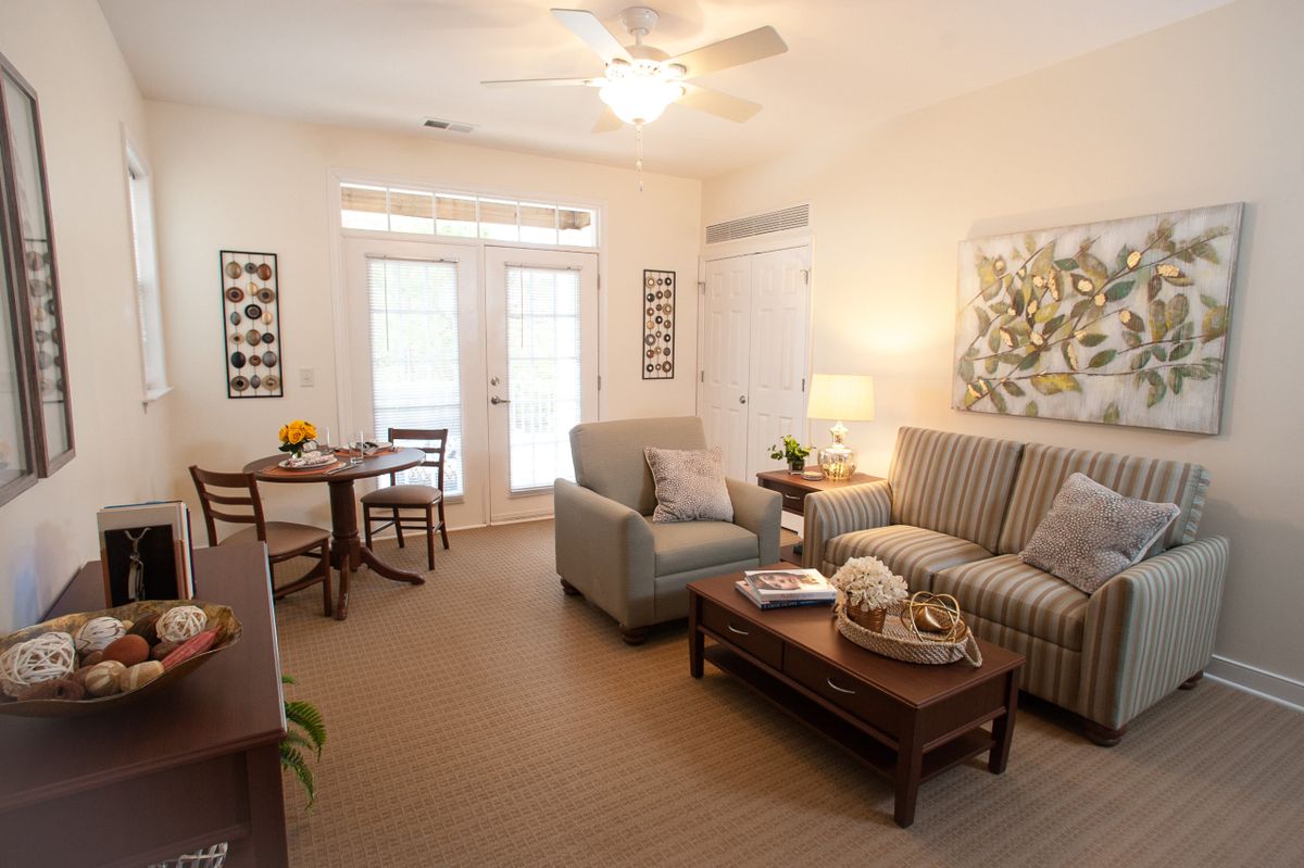 A cozy living room with a sofa, coffee table, small dining area, and tasteful decor.