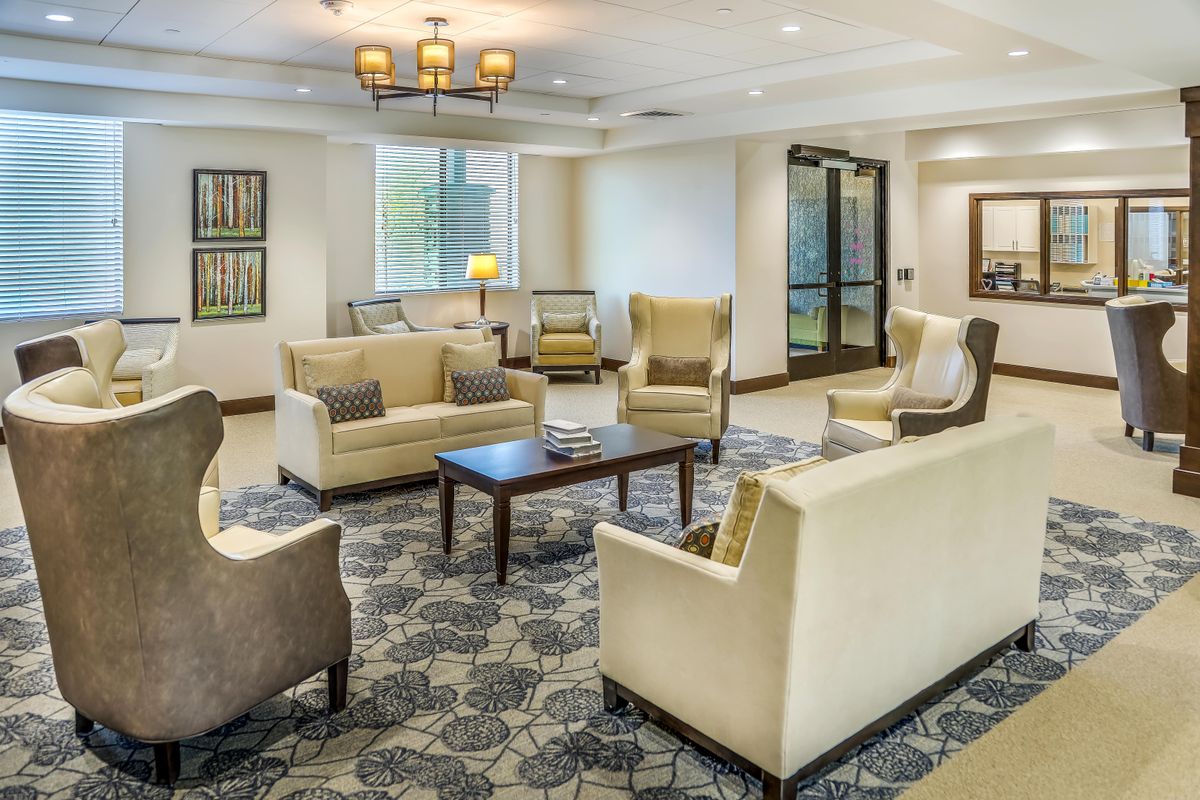 A cozy lobby seating area with armchairs and a coffee table under warm lighting.