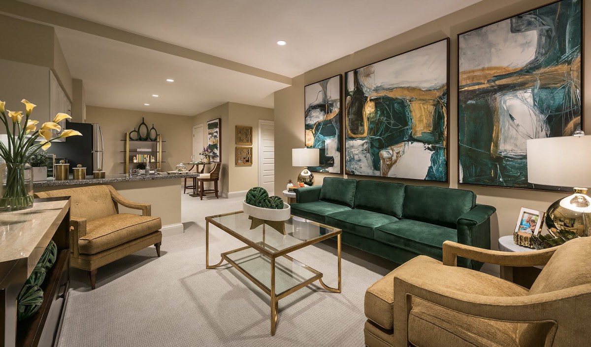 A modern living room with a green sofa and abstract artwork on the wall.