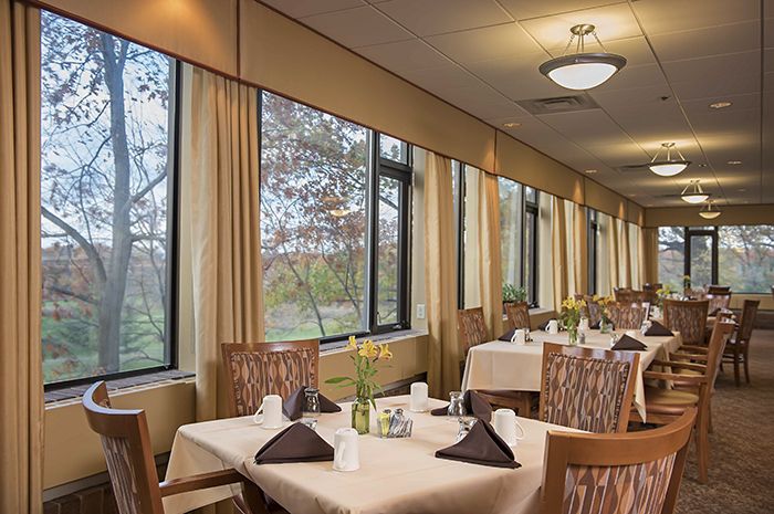 A cozy restaurant dining area with neatly set tables and large windows.