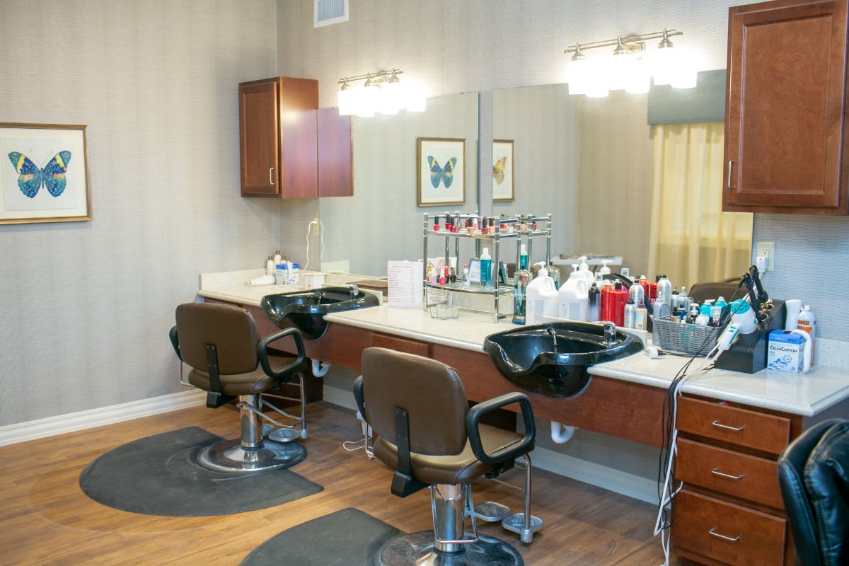 A well-equipped beauty salon with styling chairs and hair care products.