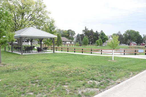 A peaceful park featuring a gazebo surrounded by lush green grass.