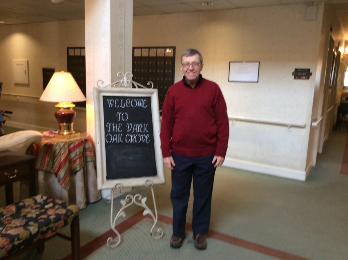 A man standing next to a welcome sign in a hallway.