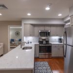 Modern kitchen with stainless steel appliances and a marble countertop.