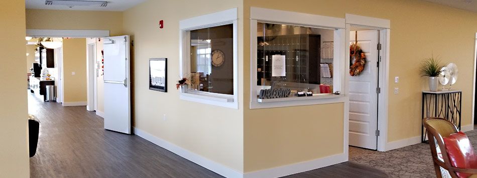 A reception area with yellow walls, featuring a counter and windows.