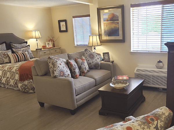 A cozy living room with a sofa, coffee table, and ambient lighting.