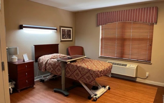 A hospital room with a single bed and medical equipment.