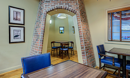 A cozy dining area with a brick archway and wooden furniture.