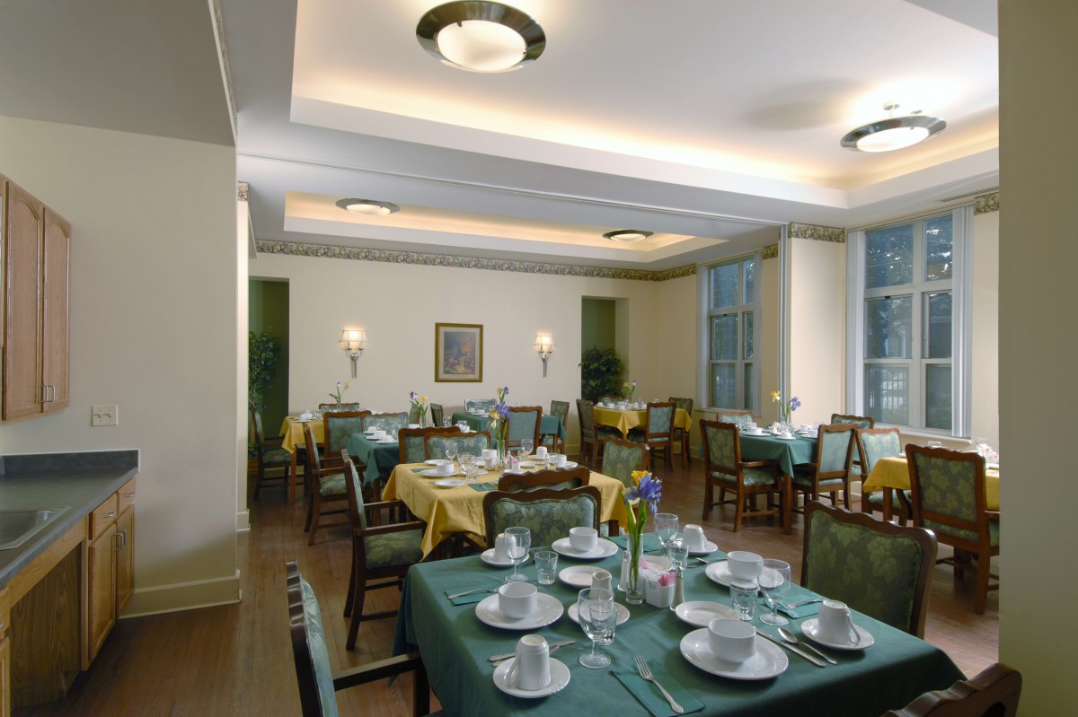 A well-arranged dining room with tables set for service, featuring elegant lighting and decor.