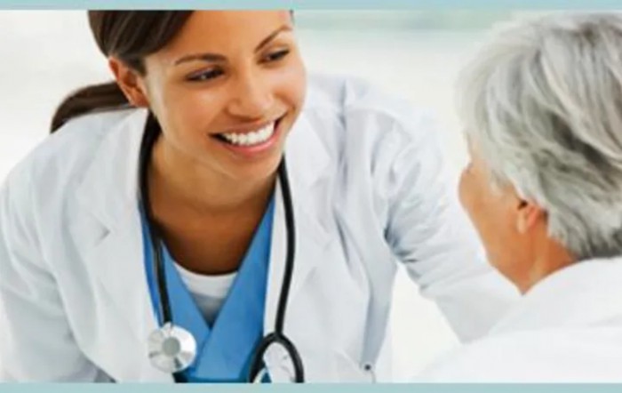A smiling healthcare professional interacting with a patient.
