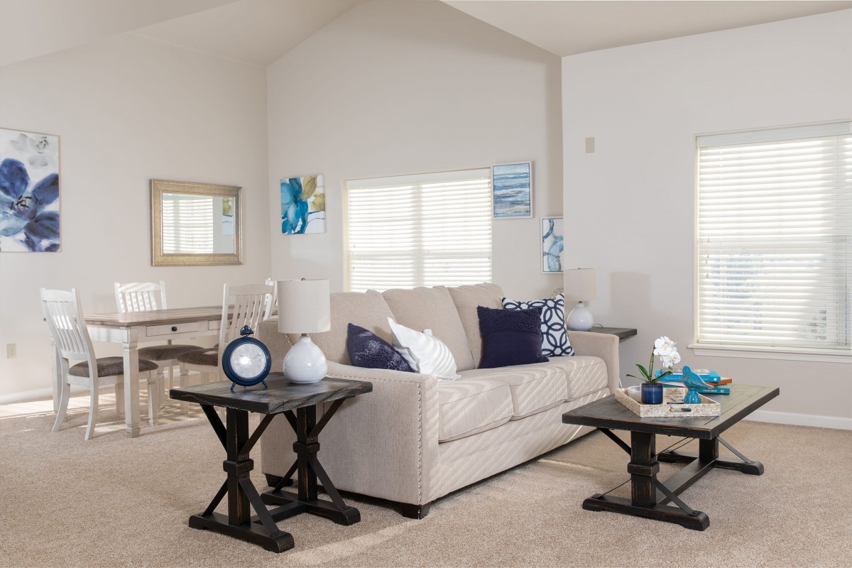 A modern living room with a beige sofa, coffee tables, and stylish decor.