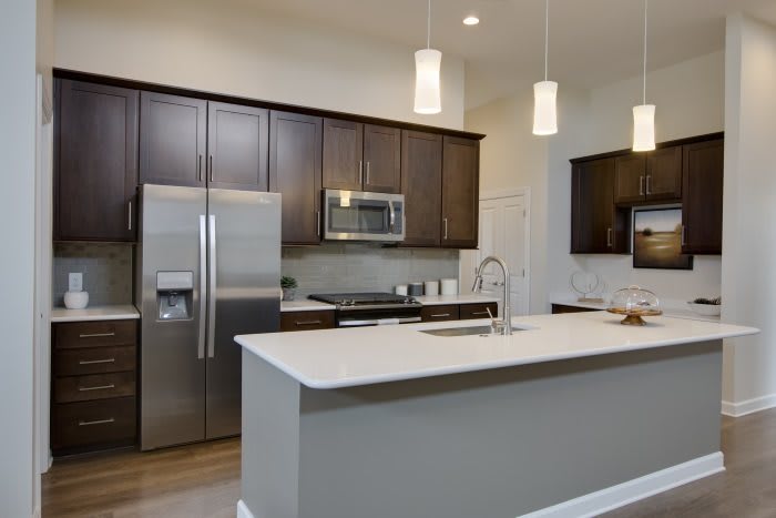 A modern kitchen with a central island and stainless steel appliances.