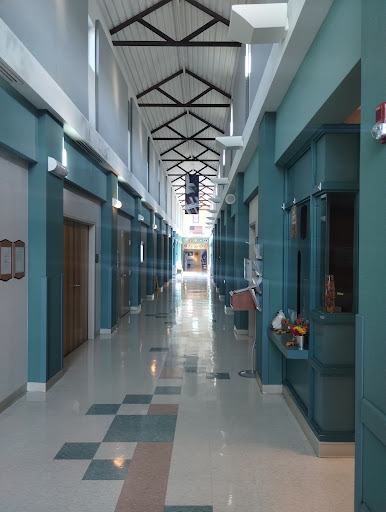 A spacious and well-lit hallway featuring modern architecture with blue walls.