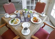 A dining table set with plates of food and beverages, ready for a meal.