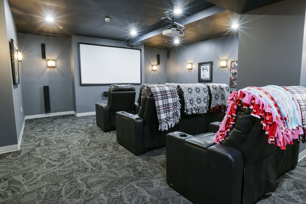 A cozy home theater setup with comfortable seating and a large projector screen.