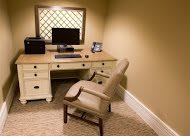 A cozy home office setup with a desk, computer, and comfortable chair.