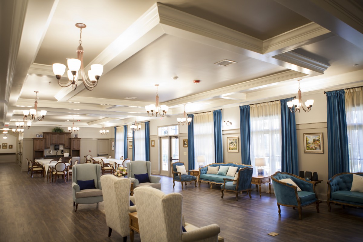 A spacious and elegantly decorated lounge area with comfortable seating and chandeliers.
