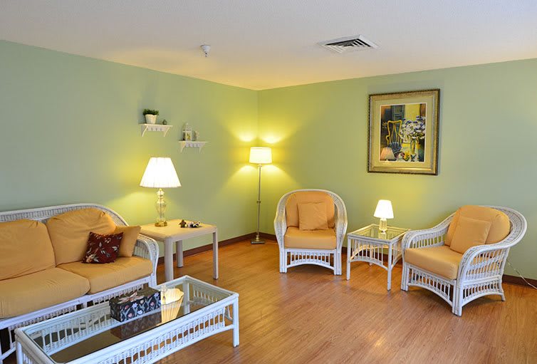 A cozy living room with wicker furniture and soft lighting on a wooden floor.