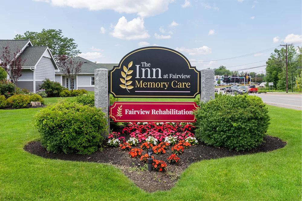 Entrance sign for The Inn at Fairview Memory Care and Fairview Rehabilitation surrounded by well-maintained landscaping.