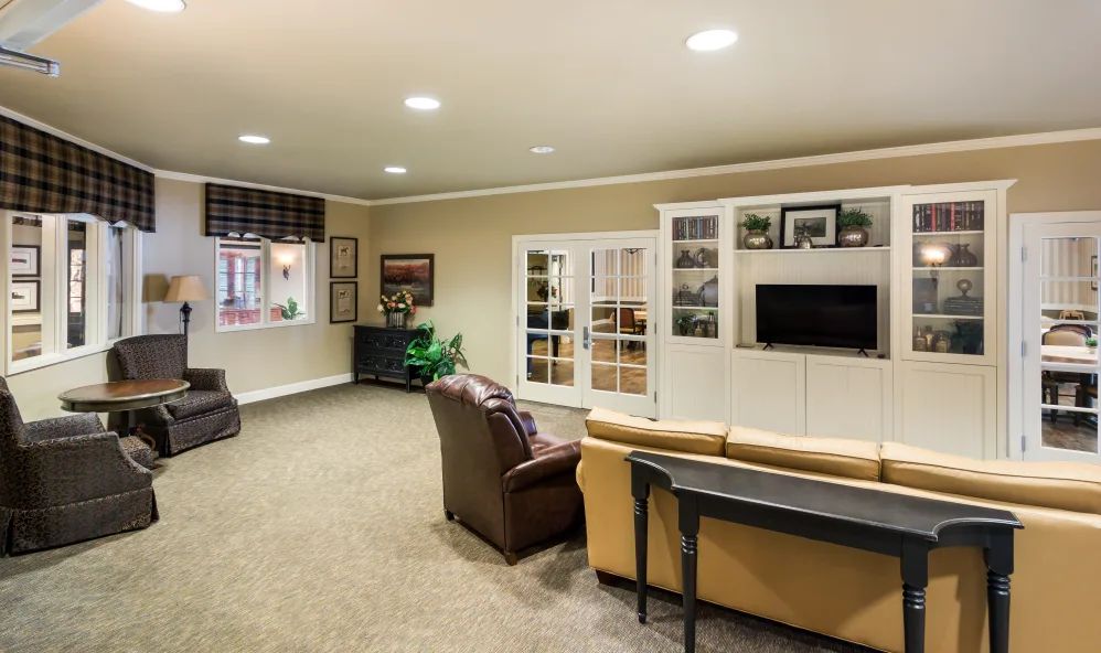 A cozy living room featuring comfortable seating and a wall-mounted TV.
