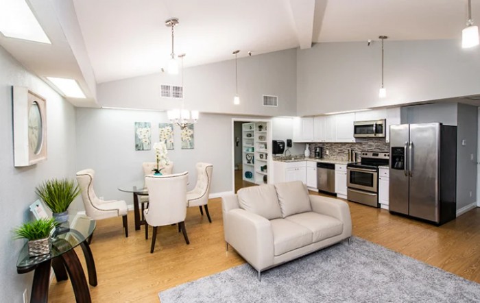 A modern open floor plan living space featuring a kitchen, dining area, and cozy seating.