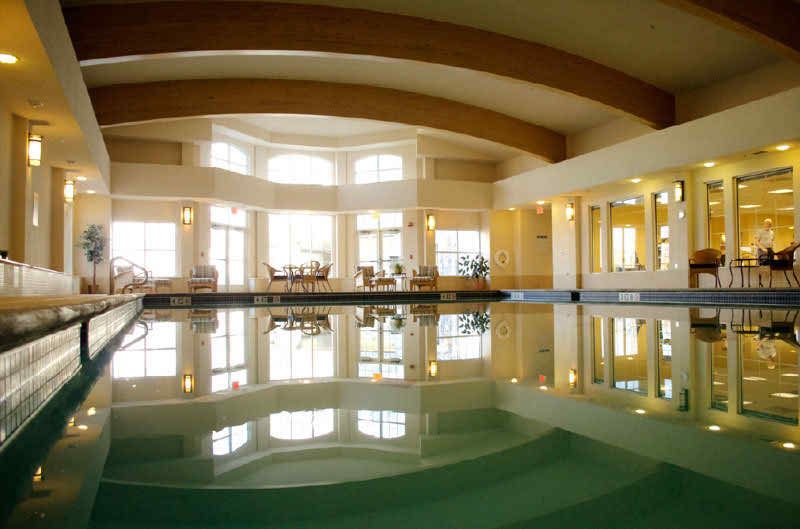A serene and luxurious indoor pool with elegant architecture and abundant natural light.