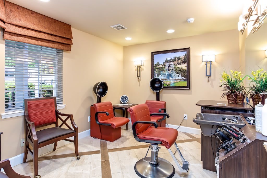A cozy hair salon interior featuring red barber chairs and classic decor.
