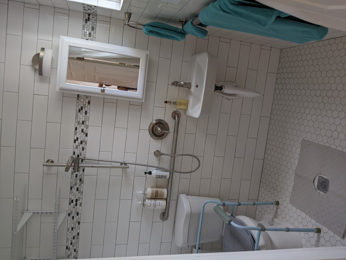 A neatly arranged bathroom with modern fixtures and teal accents.