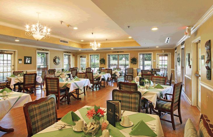 A well-lit dining area with elegantly set tables and chairs, featuring a warm and inviting atmosphere.