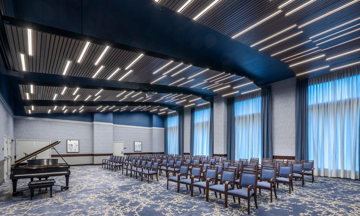 A modern conference room with rows of empty chairs and ample lighting.
