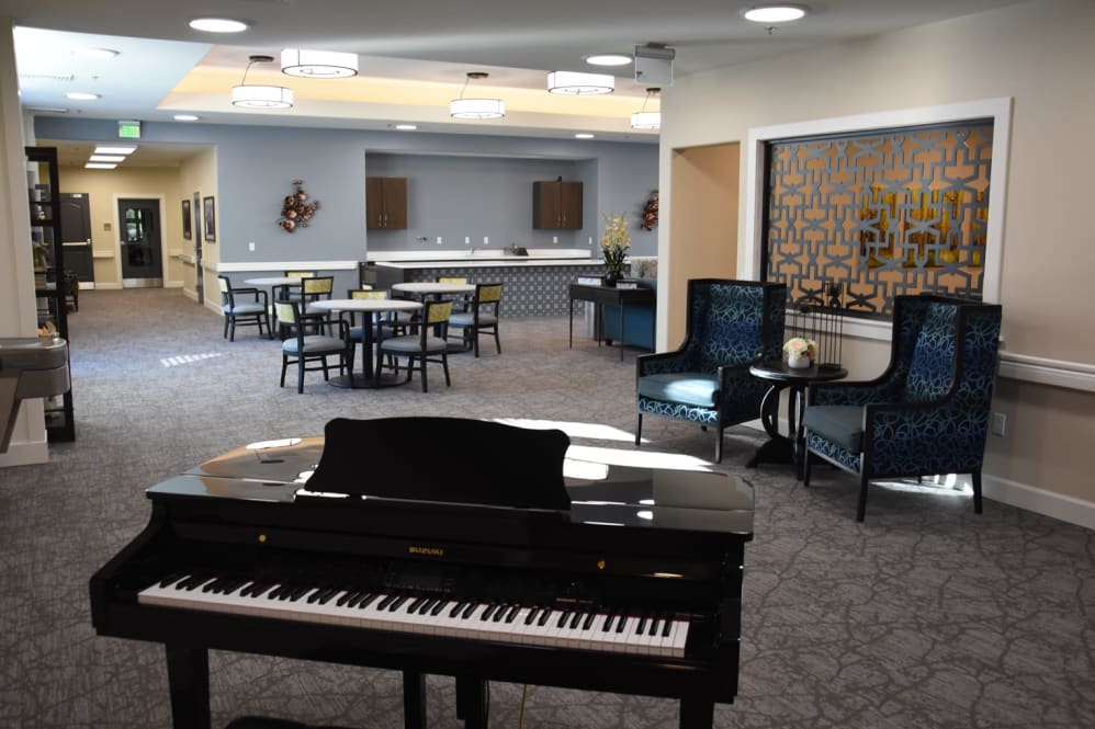 A spacious lounge area with a piano and comfortable seating.