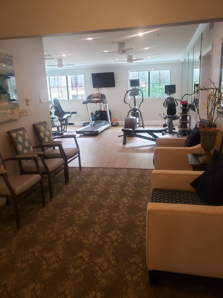A compact gym area featuring various exercise equipment and seating options.