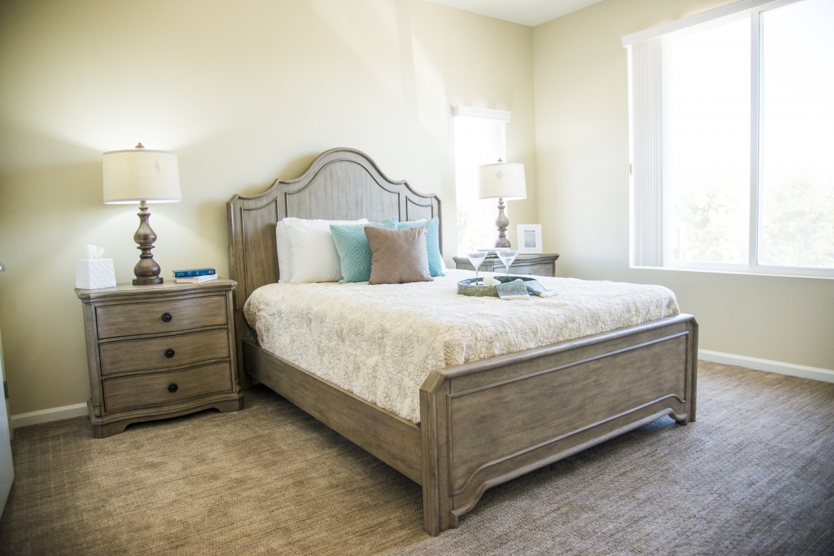 A cozy bedroom with a neatly made bed and elegant furniture.